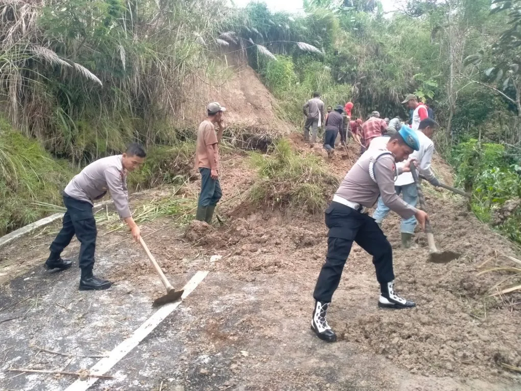 ersonel Polsek Wih Pesam Polres Bener Meriah Bersama warga membersihkan Longsor Di Badan Jalan.[Ist]