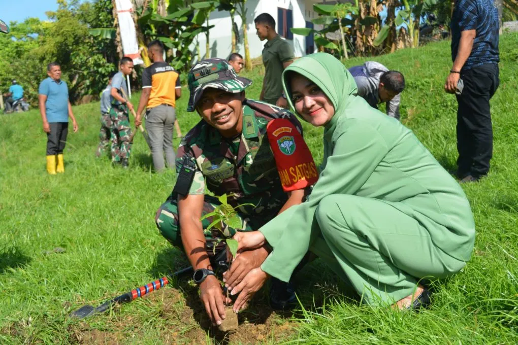 Dandim 0103 Aceh Utara, Letkol Kav Makhyar didampingi Ketua Persit KCK Ny. Raena Makhyar saat menanam secara simbolis 200 pohon mahoni di Desa Paloh Punti, Kecamatan Muara Satu.